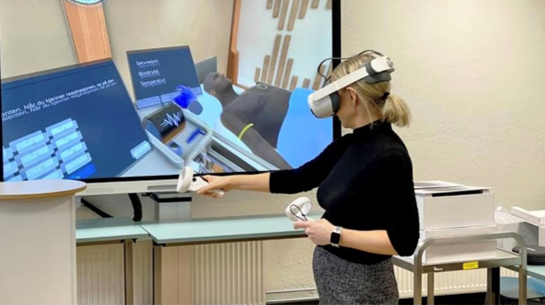 Birgitte Husberg demonstrerer hvordan helsestudentene kan øve seg på pasienthåndtering med VR-briller. - Klikk for stort bilde