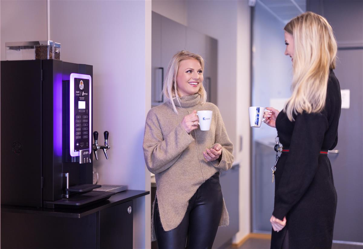 To damer nyter kaffe på jobb. - Klikk for stort bilde