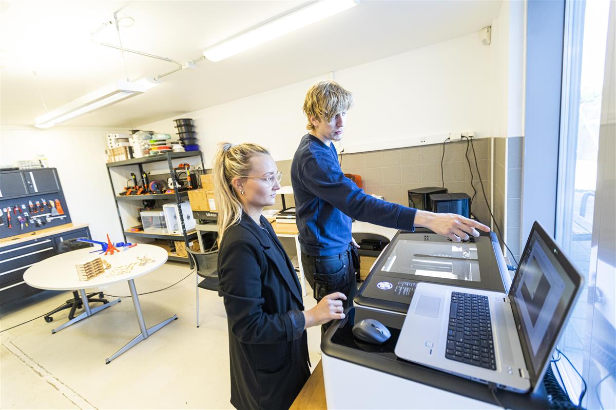 Lærer viser student laboratoriearbeid. - Klikk for stort bilde